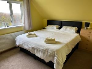 弗兰伯勒Puffin Place的一间卧室配有一张床,上面有两条毛巾