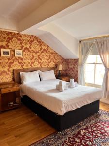 利物浦友来套房酒店的一间卧室设有一张大床和一个窗户。