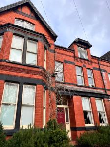利物浦友来套房酒店的一座红色砖砌的旧房子,设有红门