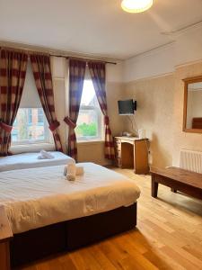 利物浦比奇格罗夫山套房酒店的一间卧室设有一张大床和一个窗户。