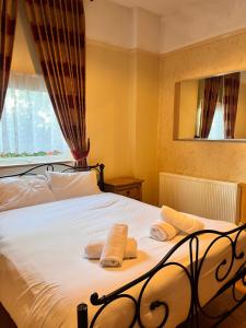 利物浦比奇格罗夫山套房酒店的一间卧室配有一张床,上面有两条毛巾