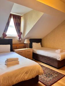 利物浦比奇格罗夫山套房酒店的阁楼卧室设有两张床和窗户。