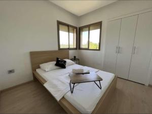 马拉喀什Prestigia Golf entrée Agate (wifi)的一间卧室配有一张大床,上面有桌子