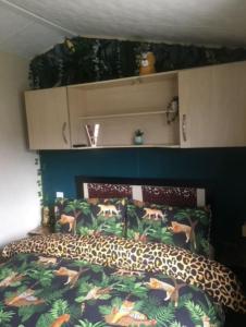坎伯利MP39 Parkdean Camber Sands的一间卧室配有一张床,床罩上备有动物