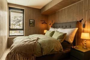 海姆瑟达尔Helt ny leilighet i Hemsedal, rett ved Fyri Resort - Ski inn - Ski out的一间卧室设有一张床和一个窗口