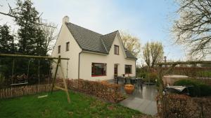 WingeneGastenverblijf 't Hof van Eden的黑色屋顶的白色房子