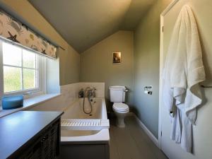 海景城Fairy Hill Cottage的带浴缸、卫生间和盥洗盆的浴室
