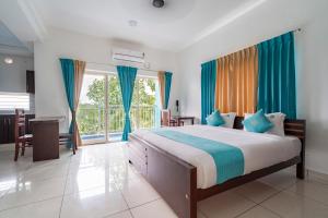 KazhakuttamBnB Homes, Technopark, Trivandrum的一间卧室配有一张带蓝色窗帘的大床