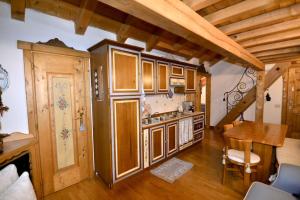 圣维托-迪卡多雷Cozy attic in the center of San Vito的一个带木制橱柜和桌子的厨房