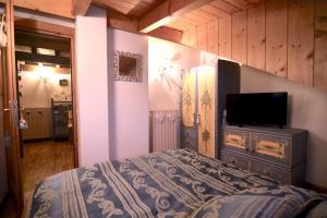 圣维托-迪卡多雷Cozy attic in the center of San Vito的一间卧室配有一张床和一台平面电视