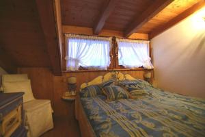 圣维托-迪卡多雷Cozy attic in the center of San Vito的一间卧室设有一张床和一个窗口