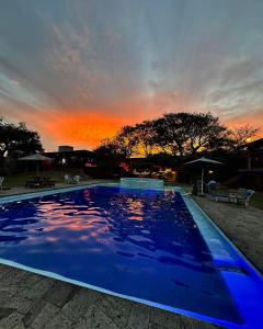 迪坡斯特兰Los Cruxes的一座蓝色的大型游泳池,背面是日落