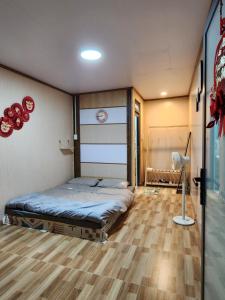 大叻Xóm nhà lá homestay的一间卧室配有一张床,铺有木地板