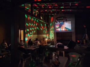 科恰班巴Casa - Villa Real de Aragón的一群人坐在酒吧里,放映屏幕