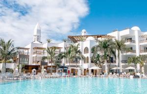 普拉亚布兰卡杨扎公主套房度假酒店的大楼前设有游泳池的酒店