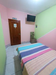 曼塔Hostal Venecia -Tu casa en Manta.的粉红色客房内的一间卧室,配有一张床