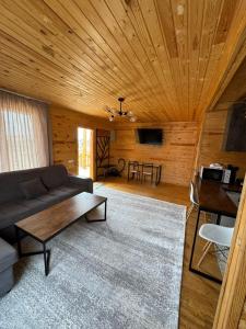 博斯特里WooD_House_Issyk-Kul的客厅配有沙发和桌子