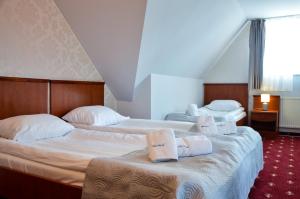 格但斯克帕斯卡尔别墅的两张位于酒店客房的床,配有毛巾