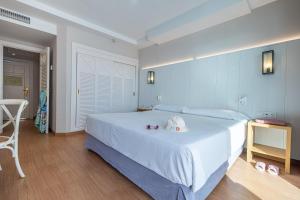 贝纳尔马德纳伊斯迪瓦托克布拉德酒店的卧室配有一张白色大床和一把椅子