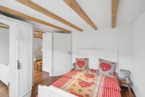 维尔德豪斯Kuschelige Ferienwohnung direkt an der Skipiste的一间卧室配有一张带红白色棉被的床