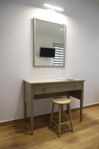 希俄斯Lythri Studios的一张带镜子和凳子的桌子