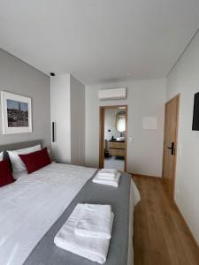 MoreiraOPORTO Suites的卧室配有带红色枕头的大型白色床
