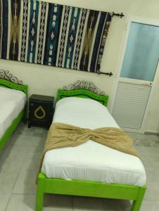 突尼斯Sidi Mehrez HOTEL的一间卧室配有一张绿床,上面有弓