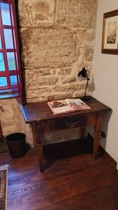 VillasanteCasa Rural del General Albelda的砖墙客房内的一张木桌