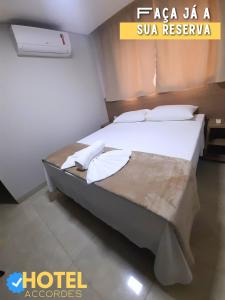 大坎普Hotel Accordes的酒店客房配有带白色床单和枕头的床。
