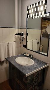 VillasanteCasa Rural del General Albelda的浴室配有盥洗盆、镜子和毛巾