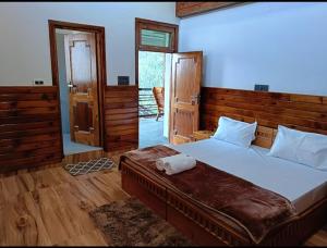 ShirirCrazy House Devku's Villa的一间卧室配有一张大床和木制床头板
