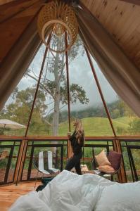 萨兰托Glamping Lumbre的一位坐在帐篷里的女人看着她的手机