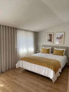 MoreiraOPORTO Suites的一间卧室配有一张带黄色枕头的大床