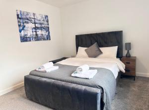 StaveleyAll Inn Apartments的一间卧室配有一张床,上面有两条毛巾