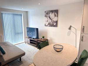 StaveleyAll Inn Apartments的客厅配有桌子和电视