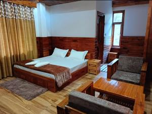 ShirirCrazy House Devku's Villa的一间卧室配有一张床、一张沙发和一把椅子