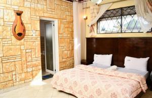 WakisoCountry lake resort Garuga的一间卧室设有一张床和石墙