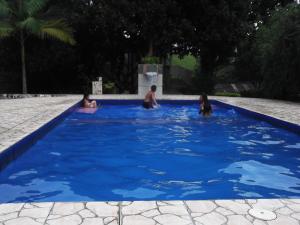 Franco da RochaSítio Colina das Flores. Lugar Encantador com Piscina para Grupos的一群人在蓝色的游泳池里