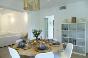 格里莫Grimaud Jardin Boreals 3 Bed Luxury Appt的一间带桌子和白色椅子的用餐室