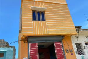 普里GRG M S M Residency Puri的黄色的建筑,上面有红色的百叶窗