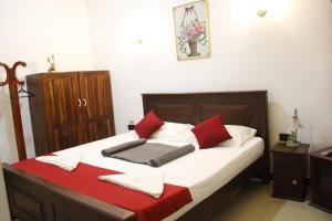 DewamottawaAirport J Dream Resort的一间卧室配有红色和白色枕头的床
