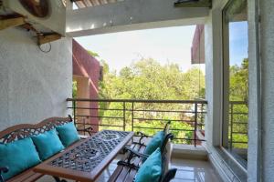 GoaPrivate Pool 3BHK Villa near Candolim的设有一个配有桌椅并享有美景的阳台。