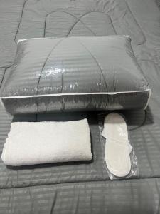 迪拜Hostel Resort VIP的一张带两个枕头的床、一条白色毛巾和枕头