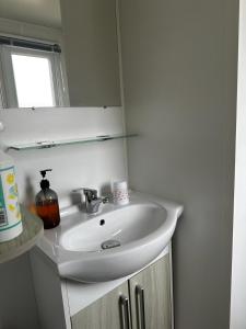 纳博讷Mobilhome clim La Falaise 4 étoiles的浴室设有白色水槽和镜子