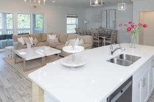 彭萨科拉New Listing, Luxury 4bd Steps to Beach Club的厨房以及带沙发和桌子的客厅。