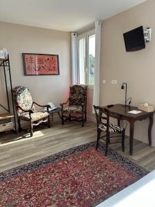 滨海自由城费南思比拉特酒店的客厅配有椅子、桌子和电视