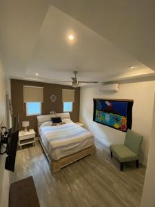 瓜纳卡斯特Playa Potrero - modern 3 BR home centrally located - Casa Coastal Serenity的一间卧室配有一张大床和一把椅子