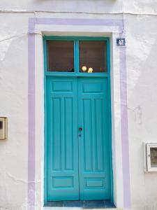 塔加纳纳TheharmonyhouseTaganana的白色建筑上一扇蓝色的门,有窗户