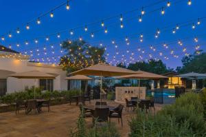 圣安东尼奥Villas at La Cantera Resort & Spa的露台在晚上提供桌子和遮阳伞
