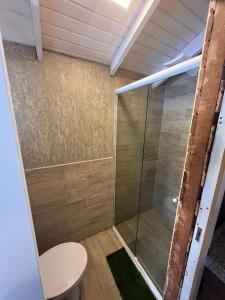 伊达贾伊Vale Beach Pousada的一间带卫生间和玻璃淋浴间的浴室